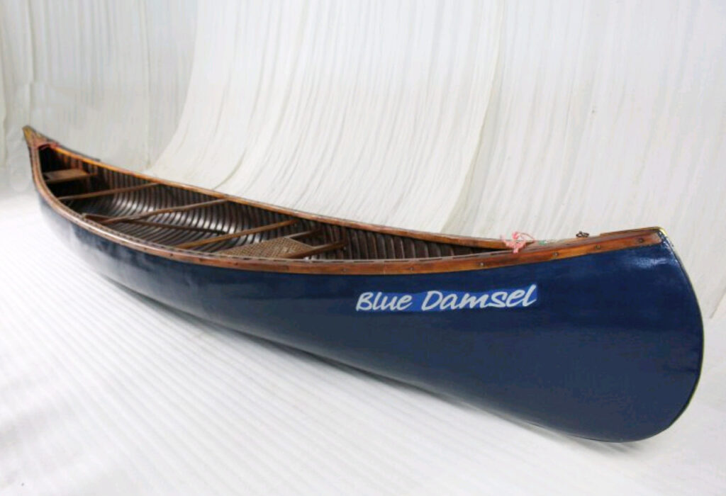 Dark blue canoe called "Blue Damsel"