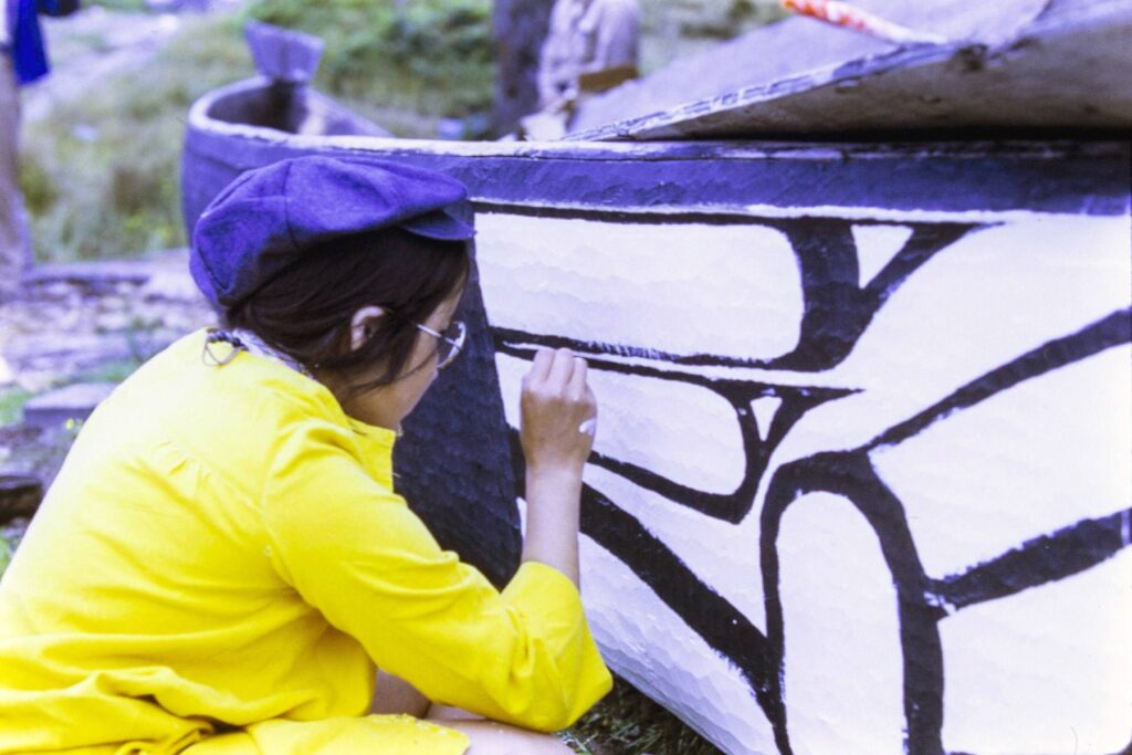 Alice Montjoy painting the side of a canoe