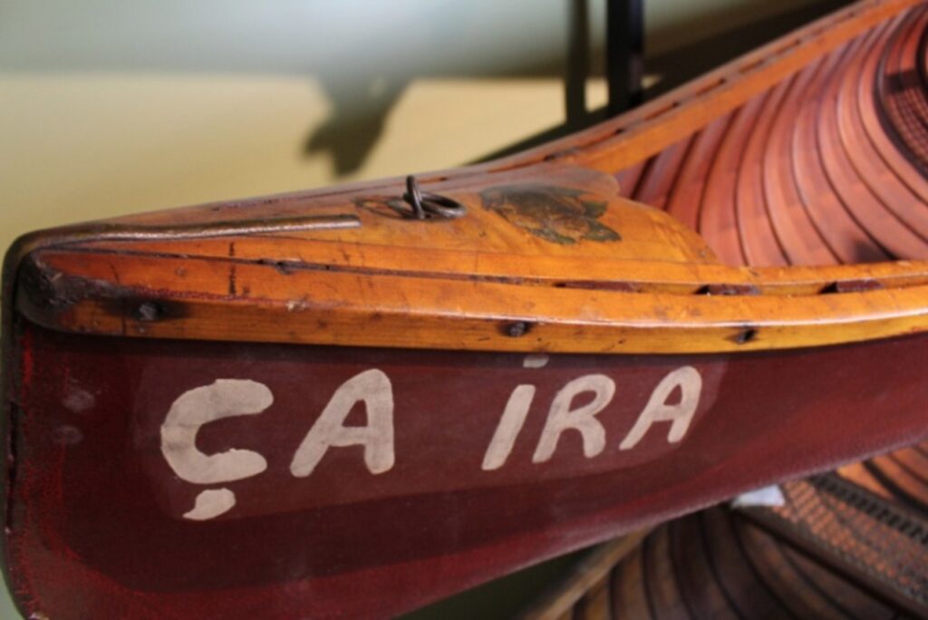 Close up shot of the painted on name "Ca Ira" on the bow of a canoe