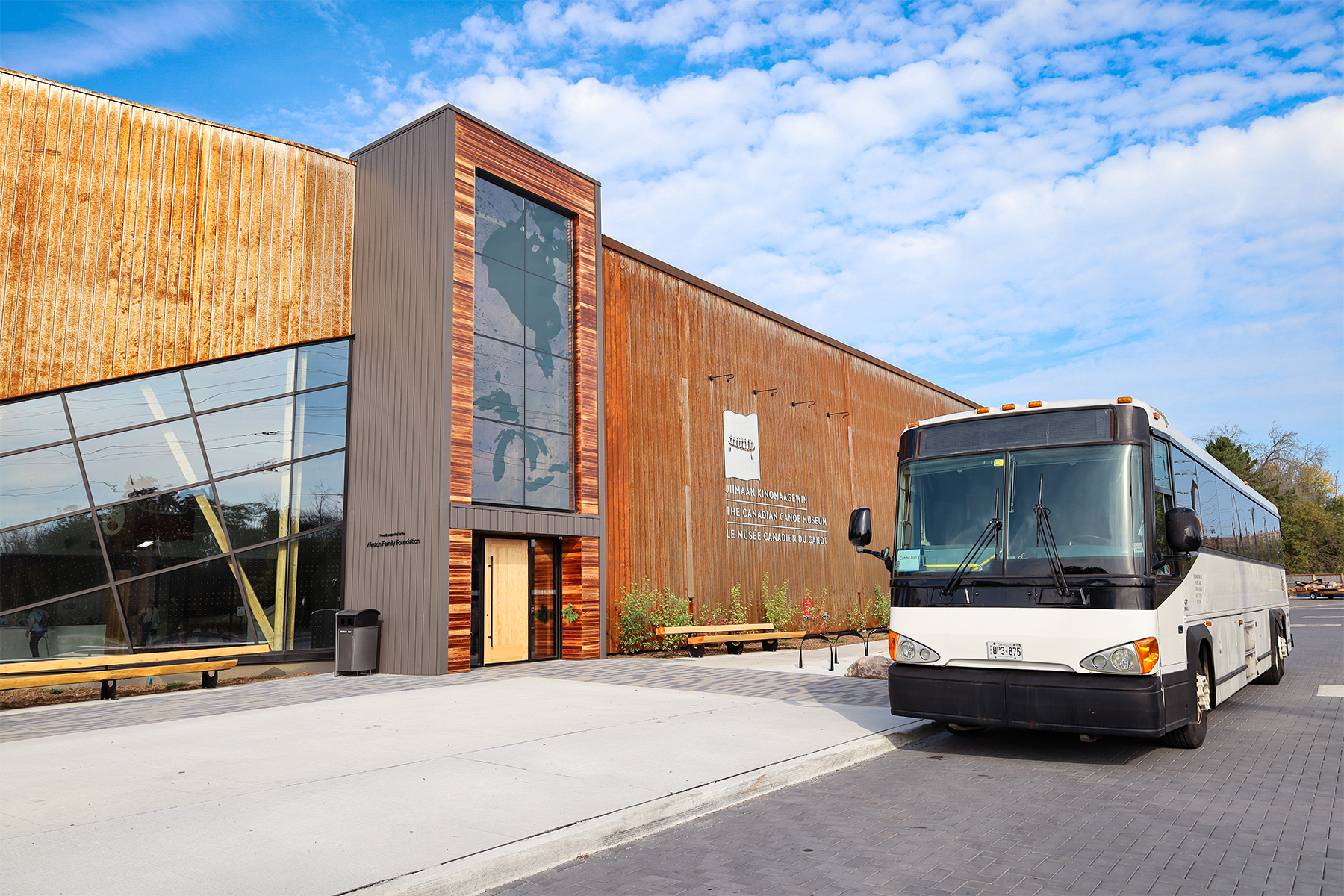 A coach bus parked outside the entrance of The Canadian Canoe Museum