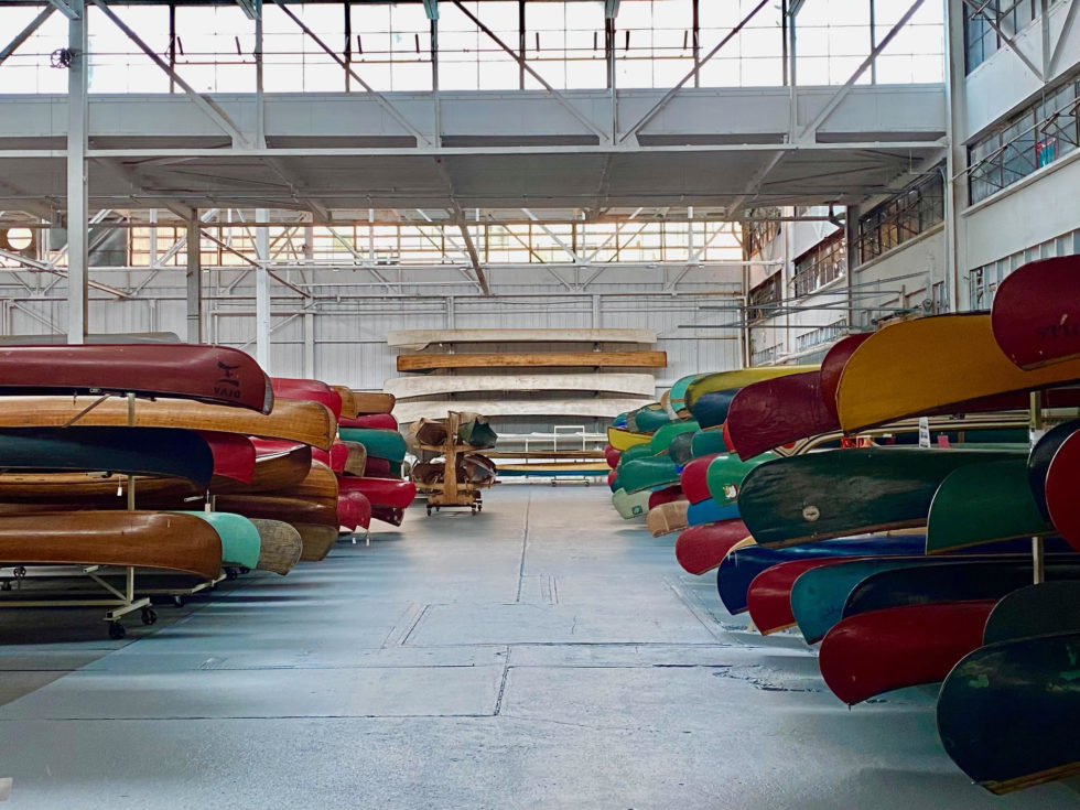 Rows of colourful canoes in large storage room