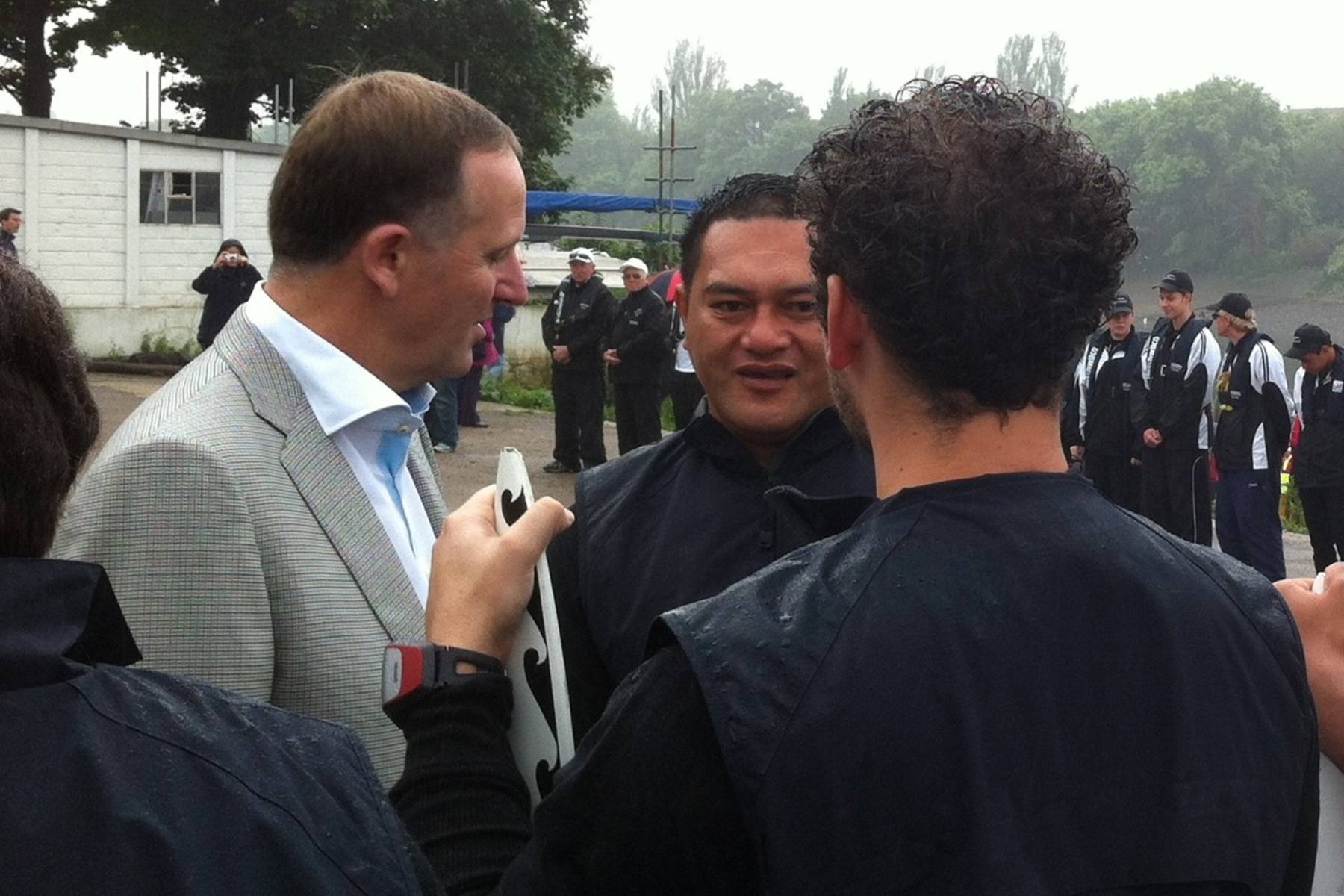 John Key and Chappie Harrison speak with a third person whose back is to the camera.