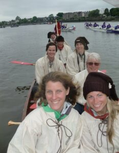 The team floats on the River Thames in a large canoe.