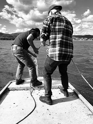 Black and white image of two men catching a salmon