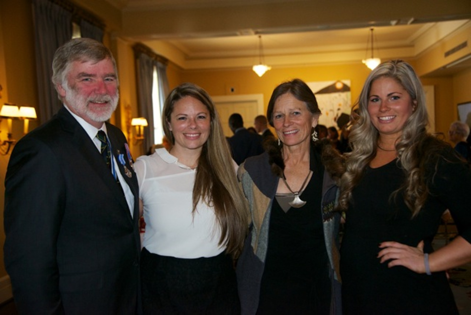 Four people dressed nicely pose for a picture