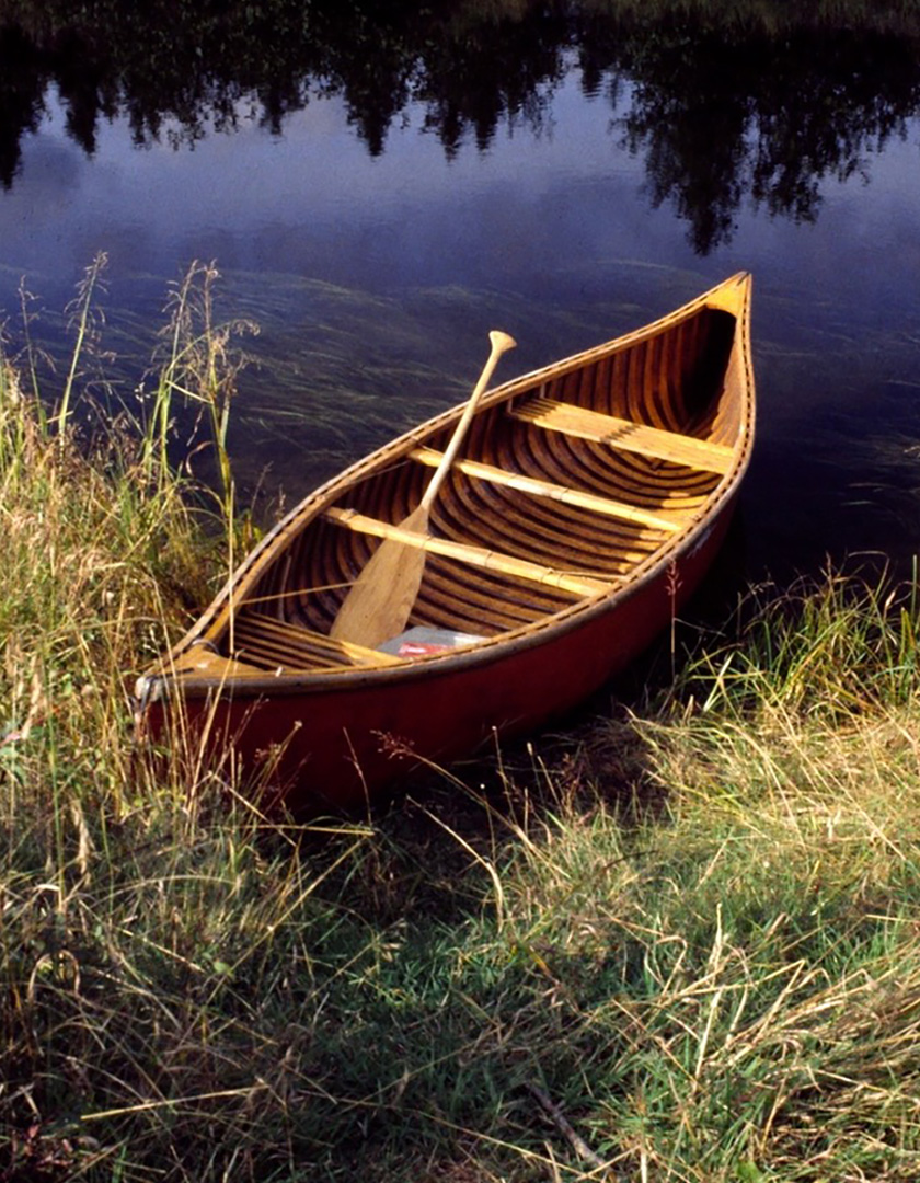 Bill Mason's red canoe sits at the edge of the lake.