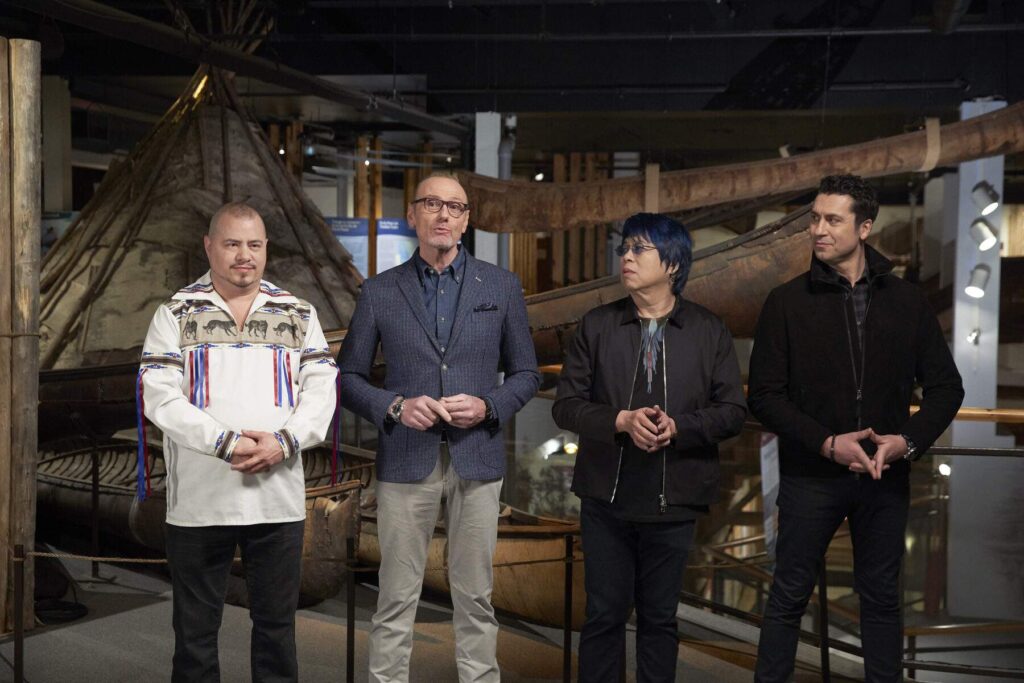 Four people stand in front of a canoe display