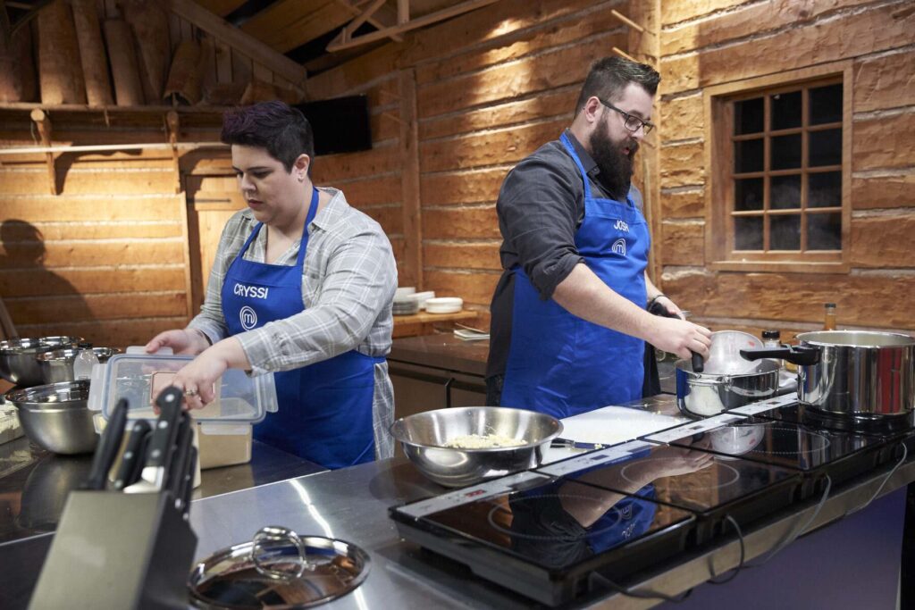 Two chefs prepare a meal at a large cooking area