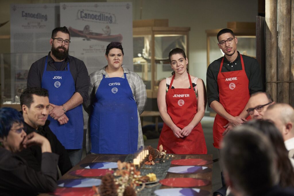 A candid photo captures four chefs standing at the end of the MasterChef table