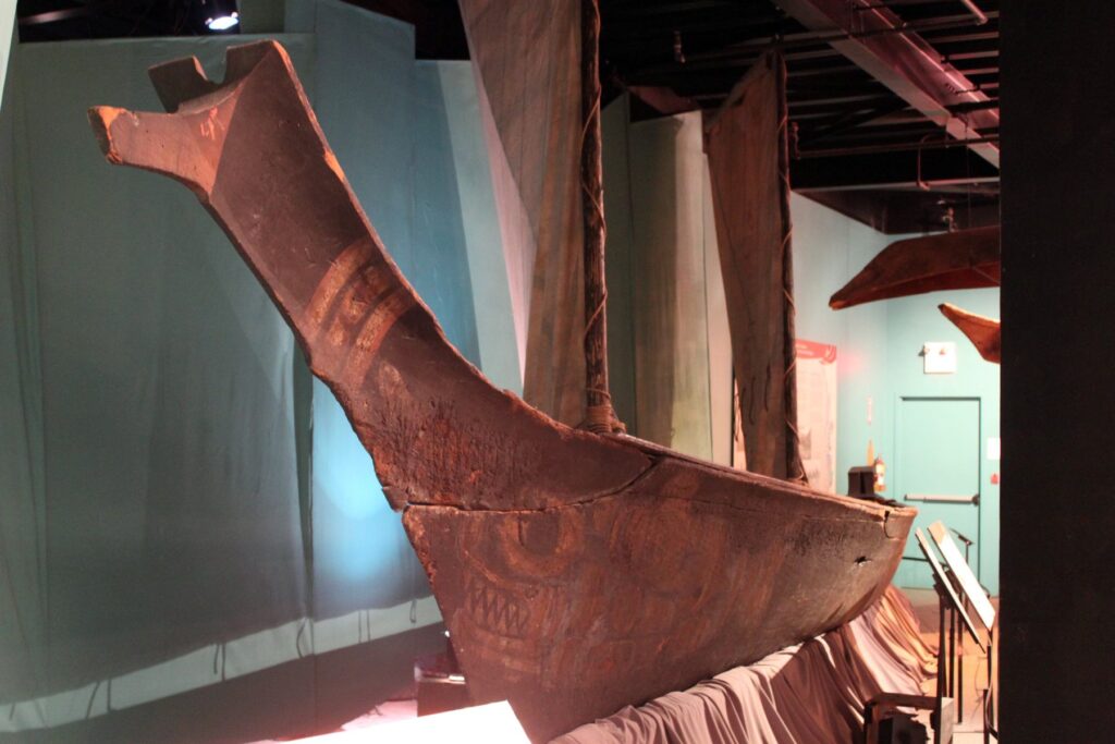 A traditional whaling canoe carved from the large red cedar sits on display.