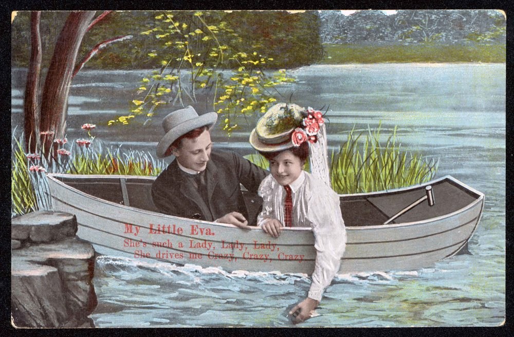 Postcard of a colourful painting. A man and woman float in a grey boat near a grassy shore while the woman leans over the edge to dip her hand in the blue waters.