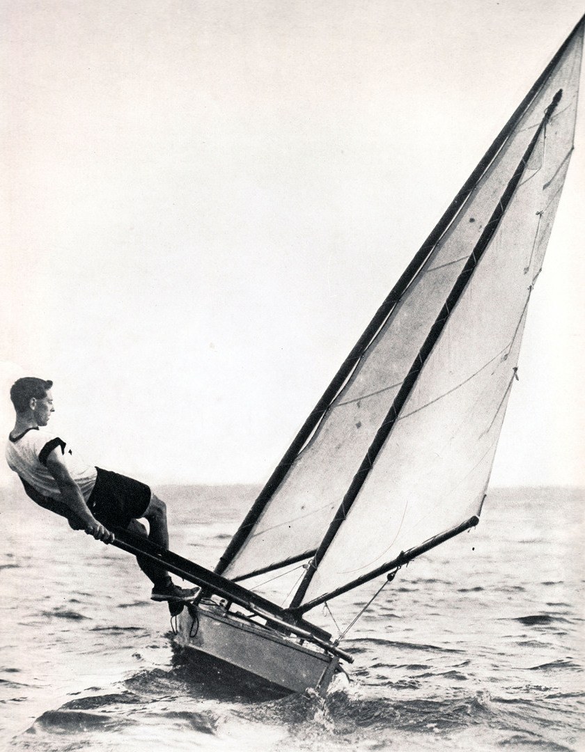 Black and white action photo of a canoe with sails