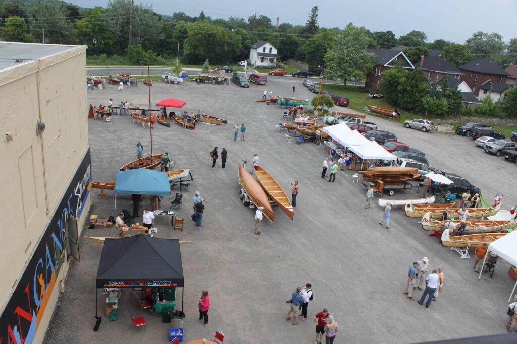 Aerial shot of Canadian Canoe Museum parking lot with several people showing their watercrafts.