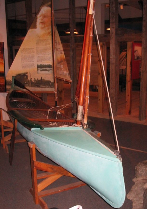 Light blue canoe with sail mast on display