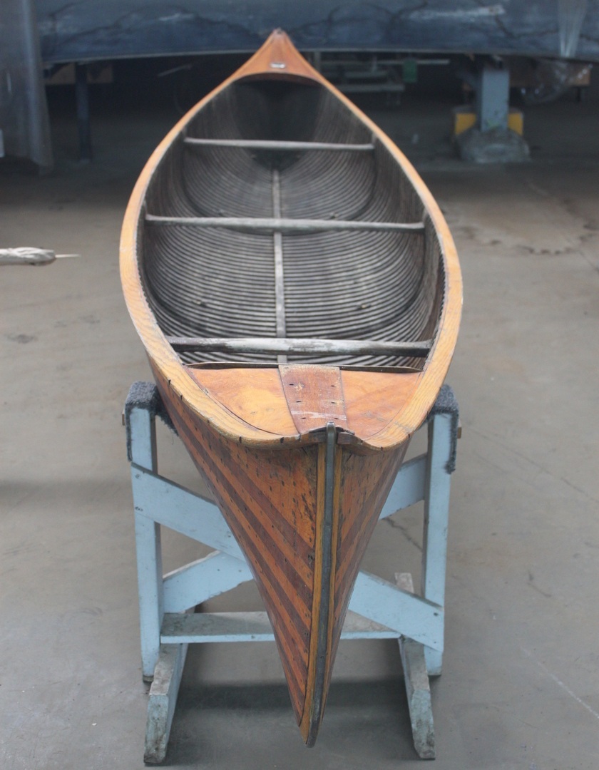 Wooden canoe sits on a blue canoe holder