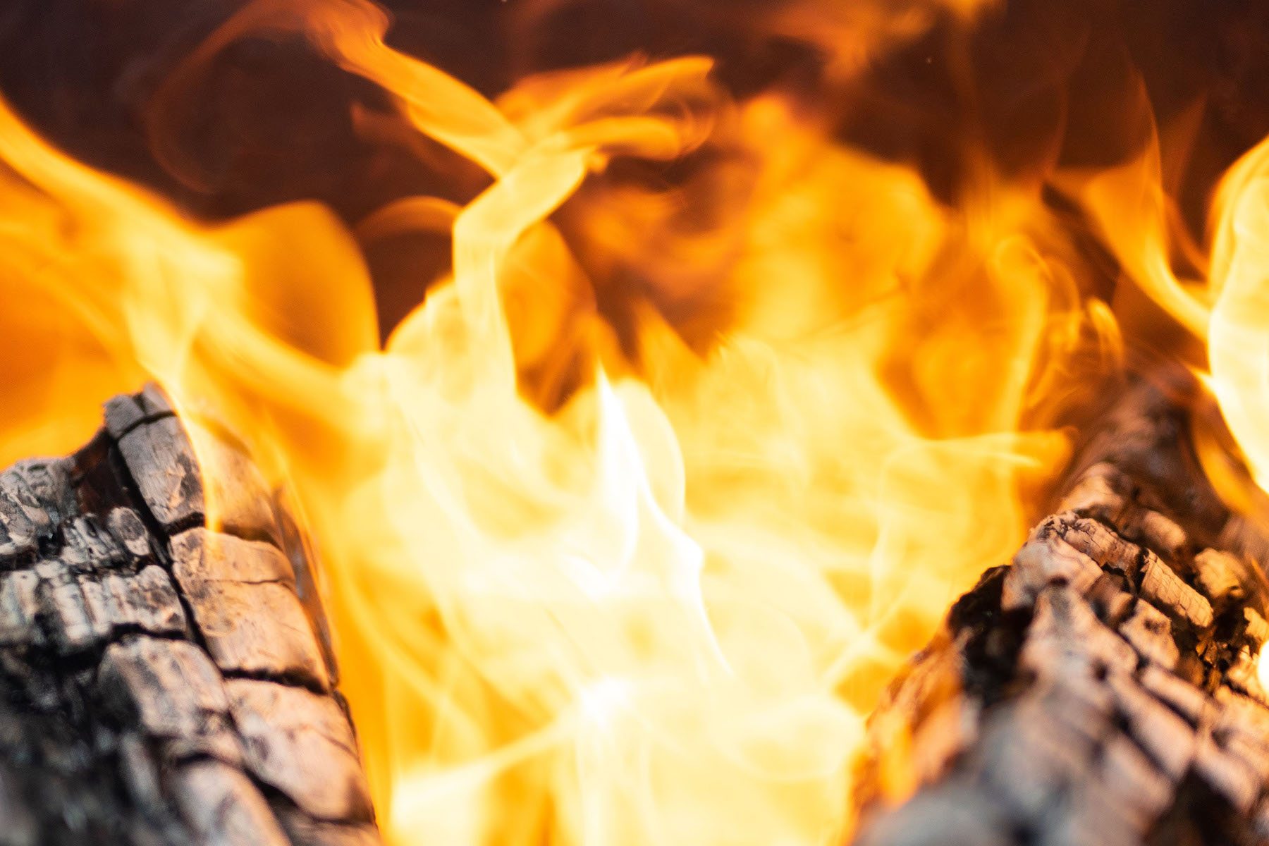 A close up image of two logs in a crackling fire.