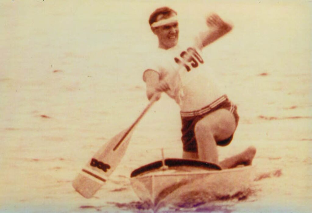 Black and white photograph of Frank Havens paddling in a competition