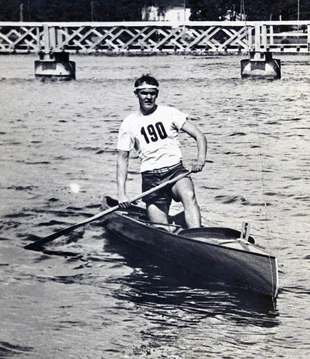 Black and white photograph of Frank Havens kneeling in his canoe.