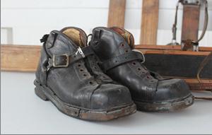 Old and worn-in black leather ski boots