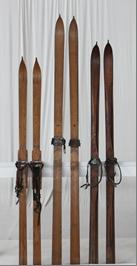 Three wooden skis displayed side by side